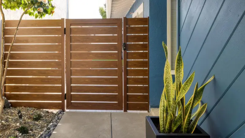 metal gate attached blue house