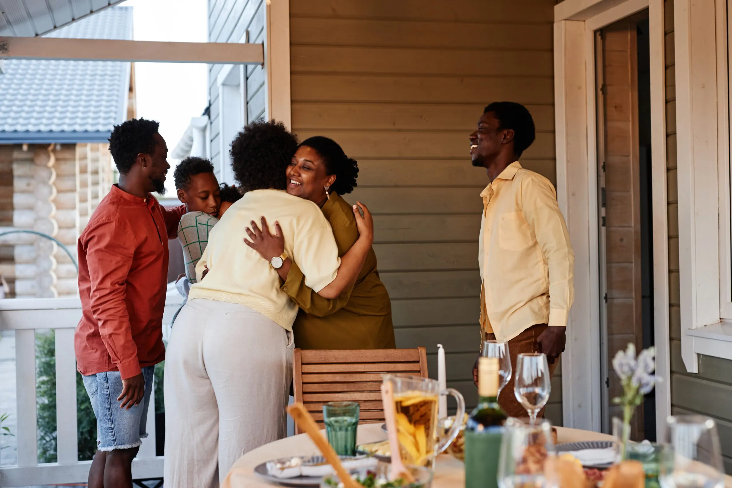 Portrait,Of,African,American,Family,Embracing,Outdoors,Welcoming,Guests,For